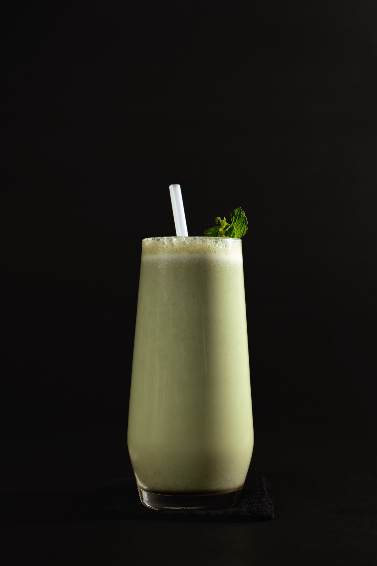 Green recovery shake garnished with mint in a tall glass